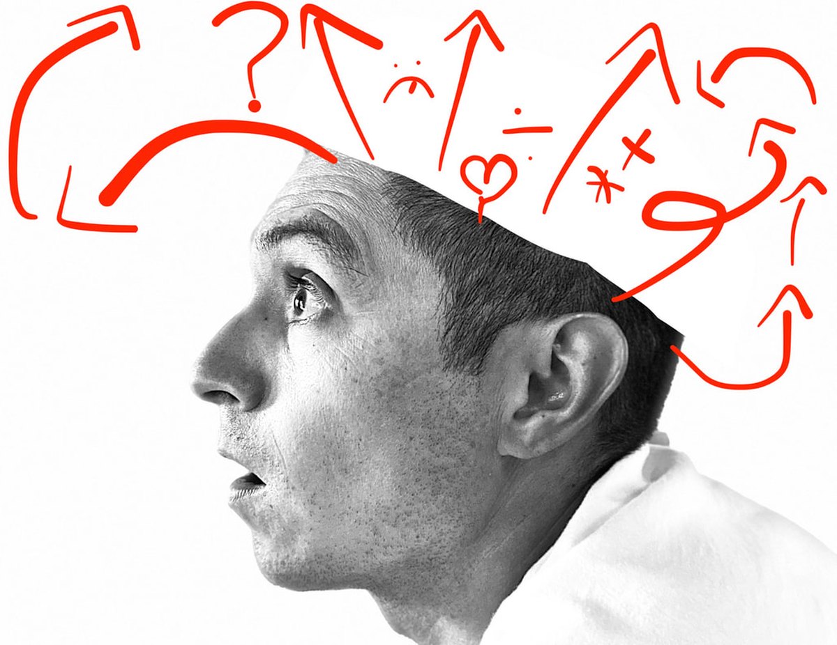 Bryant Benitez in profile, looking up at hand-drawn red arrows, question marks and symbols above his head